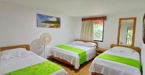 バイーア・ソラノにあるPlaya de Oro Lodgeのベッドルーム1室(ベッド2台、ファン付)