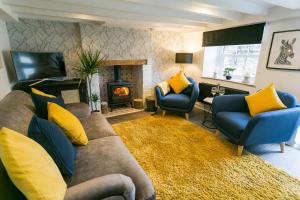 a living room with a couch and chairs and a fireplace at 3 Greenfield Terrace in Menai Bridge