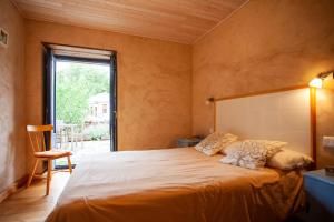 um quarto com uma cama grande e uma janela em CASA COLOMBA em Santa Colomba de Somoza