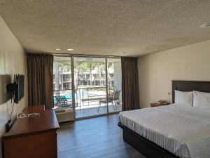 a hotel room with a bed and a balcony at Valley Inn in Mission Hills