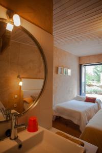 Un baño con lavabo, cama y espejo. en CASA COLOMBA, en Santa Colomba de Somoza