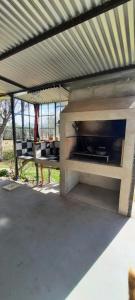 an outdoor oven with a table under a roof at Habitación Suite Sami Llankay in Villa Ciudad Parque