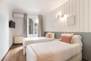 a hotel room with two beds and a window at Roisa Centro in Madrid