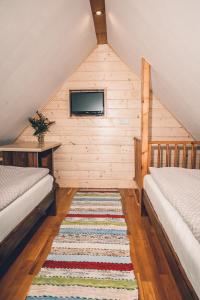 a attic room with two beds and a rug at Willa Szarotka in Rabka