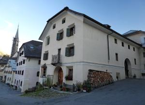 un gran edificio blanco con una torre en el fondo en Stilvolle 2,5 Zimmer, Ferienwohnung in Sent, en Scuol