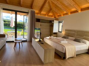 a bedroom with a large bed and a large window at La Reserva de Los Campos in Cadavedo