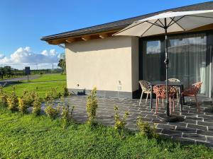 a patio with a table and chairs and an umbrella at La Reserva de Los Campos in Cadavedo