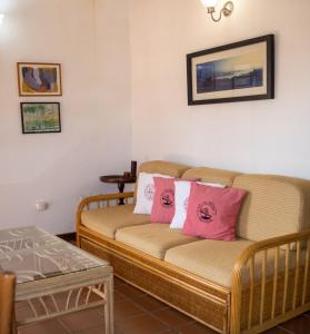 salon z kanapą i różowymi poduszkami w obiekcie Esperando solo por ti.. w mieście Pampatar