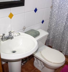 Łazienka z białą toaletą i umywalką w obiekcie Esperando solo por ti.. w mieście Pampatar