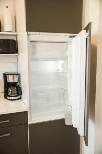 an empty refrigerator with its door open in a kitchen at Shine Apartment Wackersdorf I in Wackersdorf