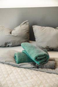stos ręczników na łóżku z poduszkami w obiekcie Shine Apartment Wackersdorf I w mieście Wackersdorf