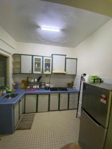 a kitchen with blue counters and a refrigerator at Seri Kasturi Apartment in Puchong