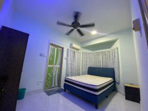 a bedroom with a bed and a ceiling fan at Seri Kasturi Apartment in Puchong