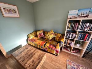 a living room with a couch and a book shelf at Seashell Cottage - Dog friendly 1 bed cottage close to the sea in Hornsea