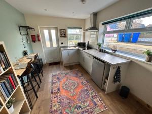 cocina con fregadero y mesa con alfombra en Seashell Cottage - Dog friendly 1 bed cottage close to the sea en Hornsea