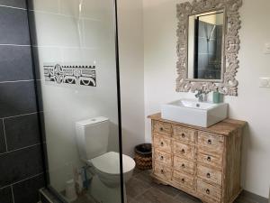 a bathroom with a toilet and a sink and a mirror at Faré Pépénai in Avatoru +9 photos