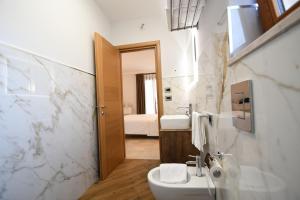 a white bathroom with a sink and a mirror at Il Filo Di Arianna-Mola-Bed and Breakfast in Mola di Bari +36 photos