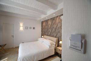 a bedroom with a white bed and a wall at Il Filo Di Arianna-Mola-Bed and Breakfast in Mola di Bari