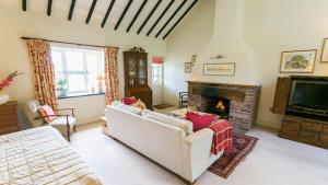 uma sala de estar com um sofá e uma lareira em Beudy Odyn em Pentraeth