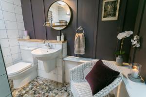 Un baño con lavabo, inodoro y espejo. en Eigionfa, en Menai Bridge 59 fotos más