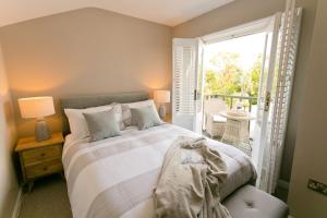 a bedroom with a large bed and a balcony at Eryl Mor in Menai Bridge