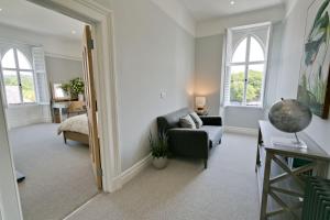 a living room with a couch and a chair and windows at Eryl Mor in Menai Bridge