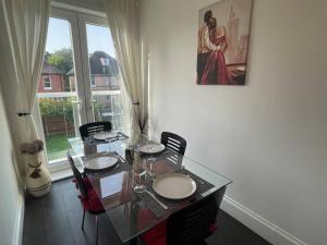 a dining room with a glass table and chairs at 3 bed flat+parking- by beaches in Parkstone