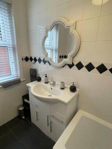 a bathroom with a sink and a mirror on the wall at 3 bed flat+parking- by beaches in Parkstone