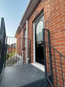 a door to a brick building with a black gate at 3 bed flat+parking- by beaches in Parkstone