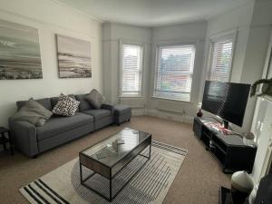 a living room with a couch and a coffee table at 3 bed flat+parking- by beaches in Parkstone