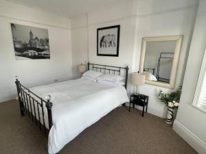 a bedroom with a large bed and a mirror at 3 bed flat+parking- by beaches in Parkstone