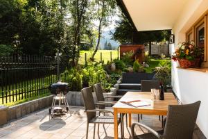 a patio with a table and chairs and a grill at Apartamenty Blisko TATR Zakopane in Zakopane