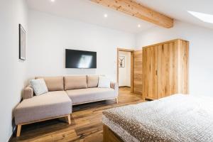 a living room with a couch and a bed at Apartments Schöneben in Ulrichsberg