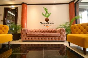un divano marrone in una hall con due sedie gialle di Sago Palm Hotel a Ocho Rios