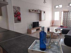 a bottle of wine and two wine glasses on a kitchen counter at Loft moderno en Fuerteventura in Puerto del Rosario