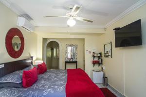 una camera con letto e ventilatore a soffitto di La Loggia Bed and Breakfast a Durban