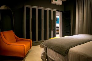 um quarto com uma cama e uma cadeira laranja em Casa Rafaela Mendoza parque y ciudad em Mendoza