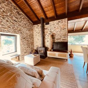 uma sala de estar com um sofá e uma parede de pedra em Casa de Areja em Lomba