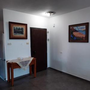 pokój z drzwiami, stołem i zdjęciem w obiekcie yael house w mieście Aszkelon