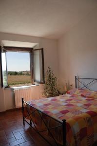 una camera da letto con un letto e una grande finestra di Agriturismo Pian dei Pini a Montiano Altre 37 foto