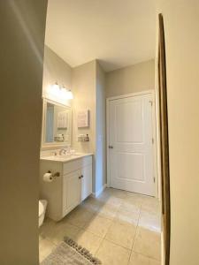 a bathroom with a sink and a toilet and a door at Cozy Corner - Family Beach Vacation Condo in Wilmington