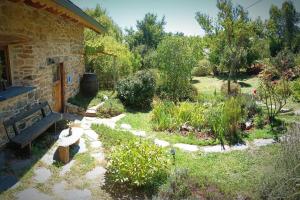 - un jardin avec un banc à côté d'une maison dans l'établissement Dríade, à Villar de las Traviesas