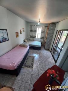 Cette petite chambre comprend deux lits et une table. dans l'établissement CTC Torre B, Centro, à Caldas Novas