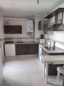 eine Küche mit Küchengeräten aus Edelstahl und einem Tisch in der Unterkunft Precioso Dúplex con terraza Vut 47-91 