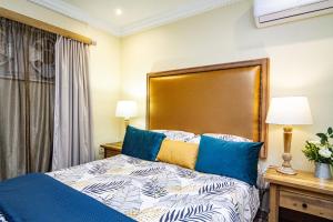 a bedroom with a bed with blue pillows at La Loggia Bed and Breakfast in Durban