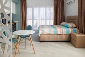 a bedroom with a bed and a table and a chair at elisio - Ninth Heaven in Braşov