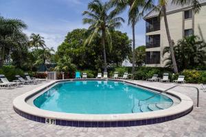 a large swimming pool with chairs and a building at Gorgeous Tennis Villa at South Seas Resort in Captiva
