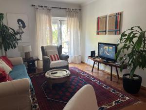salon z kanapą i telewizorem w obiekcie Apartamento de charme w mieście Cascais