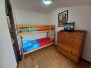 a bedroom with two bunk beds and a dresser with a laptop at Roma a un passo e il mare in casa in Marina di Cerveteri