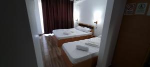 een hotelkamer met 2 bedden en handdoeken erop bij Hotel Blue Sky Resort in Eforie Nord